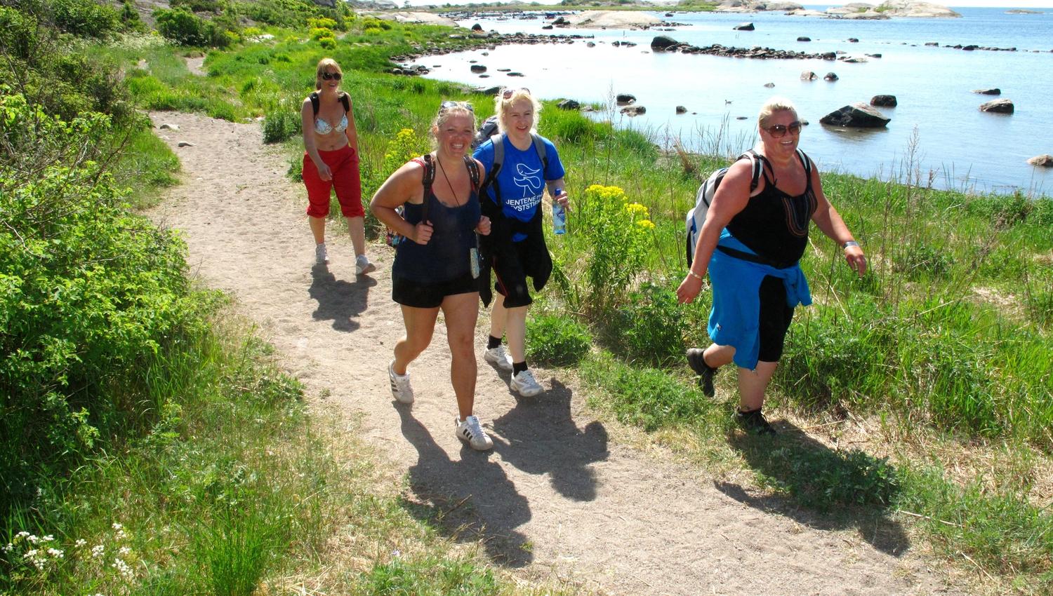 Folk går tur på kyststi