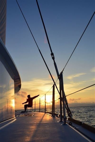 A person enjoying the view from the boat during the midnight sun