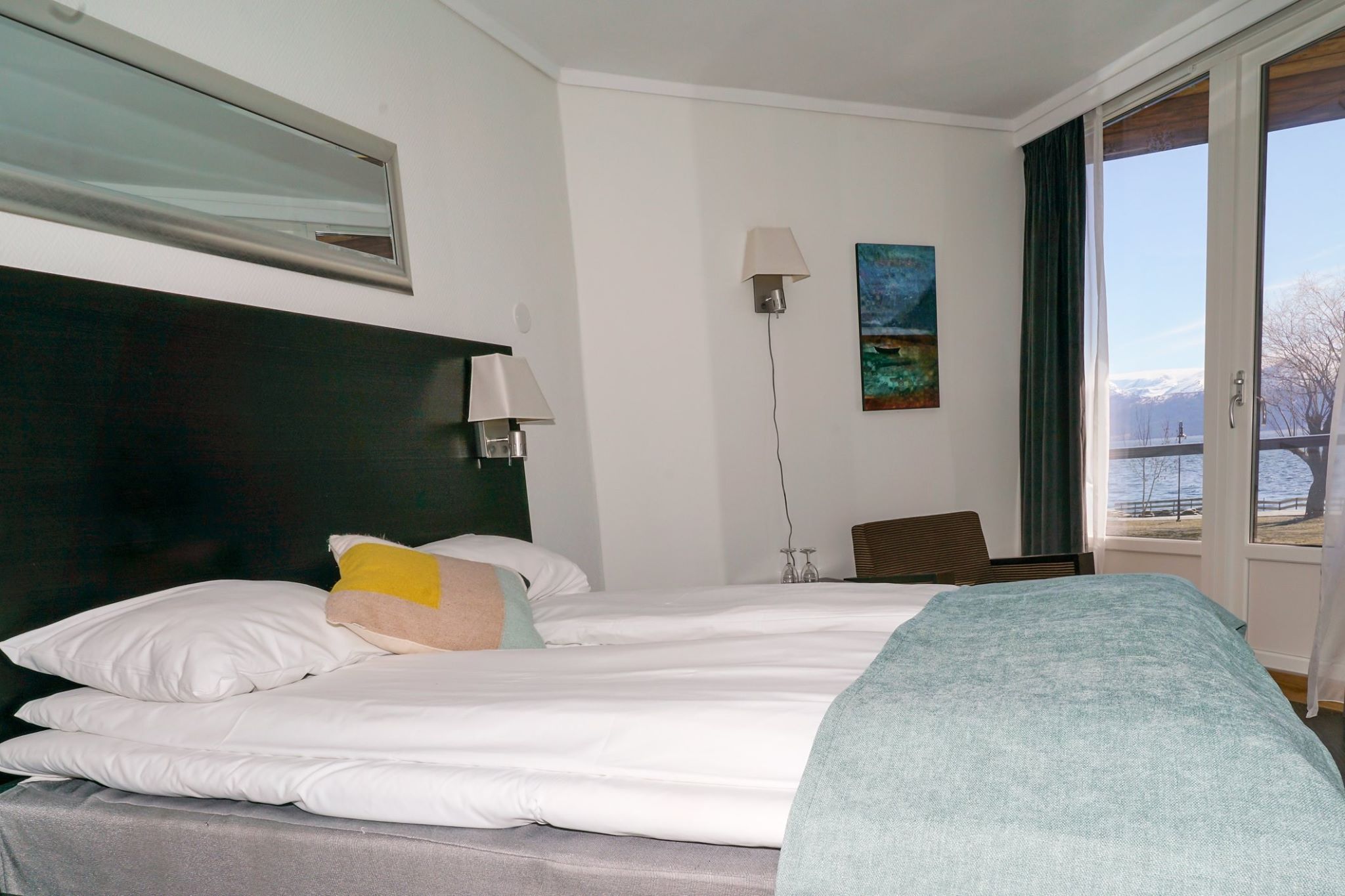Cozy hotel room with a double bed and panoramic fjord views.
