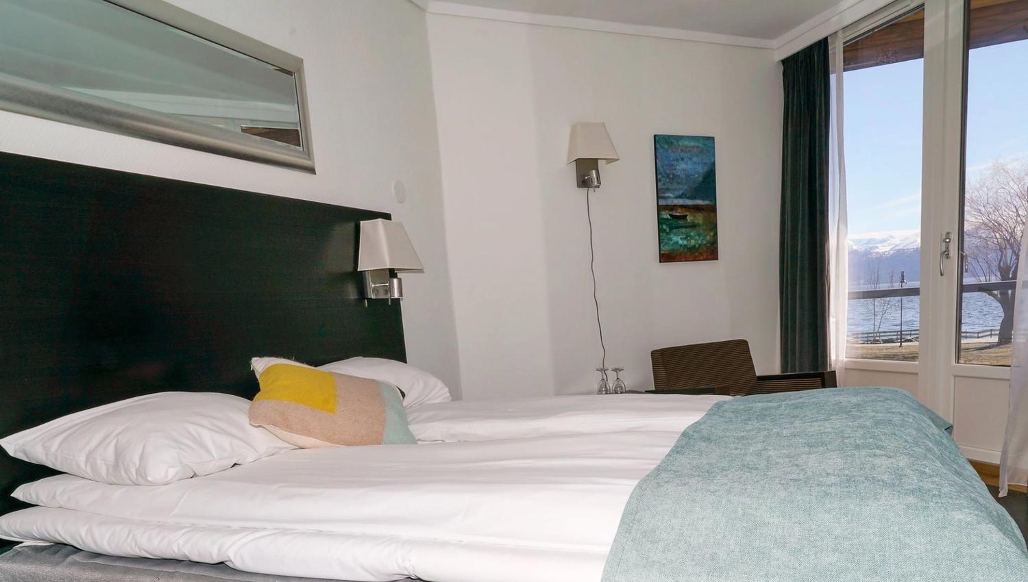 Cozy hotel room with a double bed and panoramic fjord views.