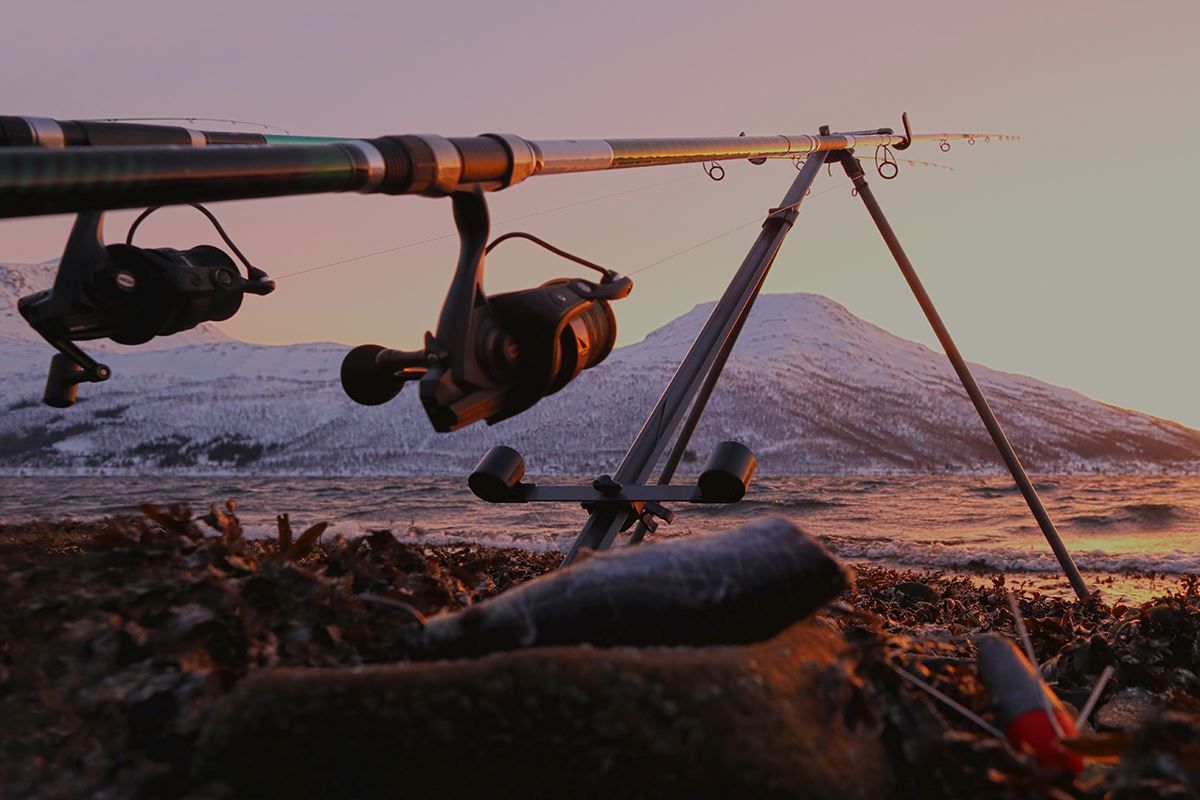 Fishing rod on a tripod with a scenic view in the background
