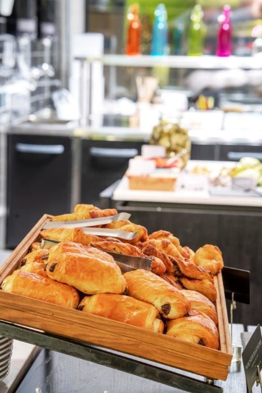 Tray of chocolate croissants in a café or bakery setting.