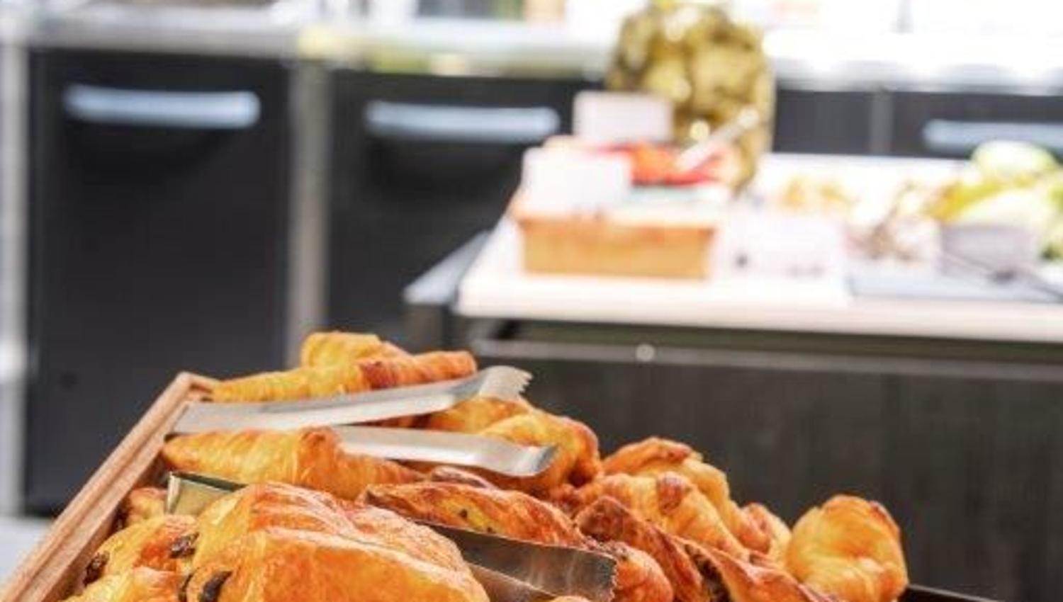 Tray of chocolate croissants in a café or bakery setting.