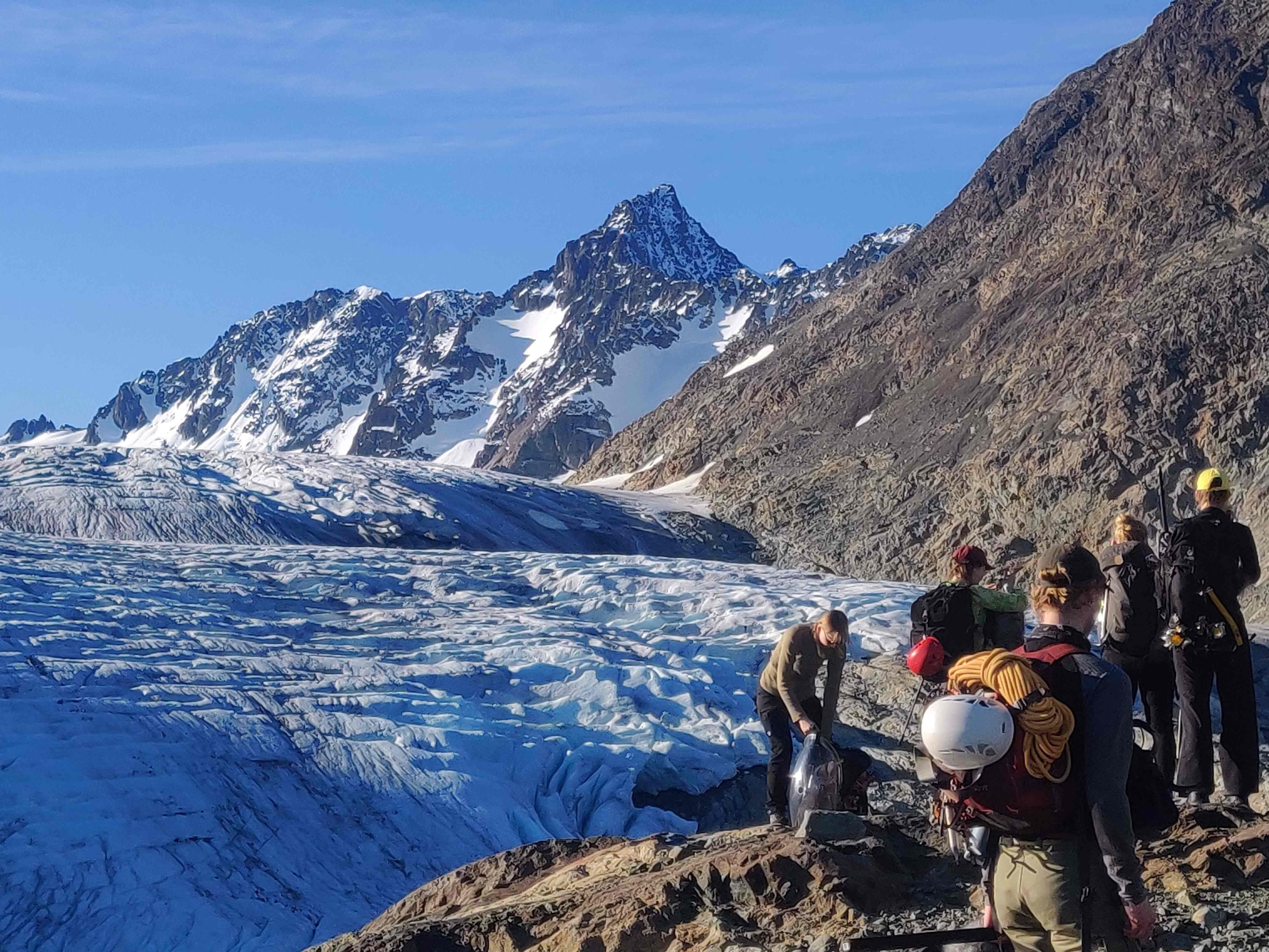 5 people beside a glacier.