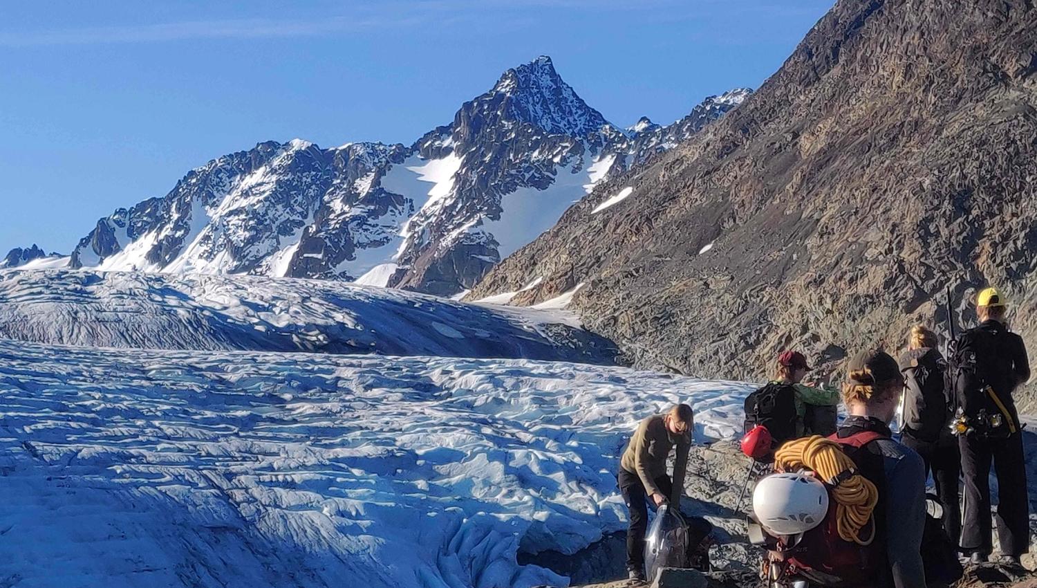 5 people beside a glacier.