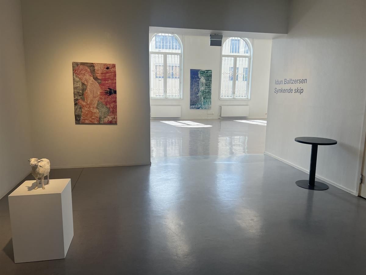 Modern exhibition space with artworks on the walls.