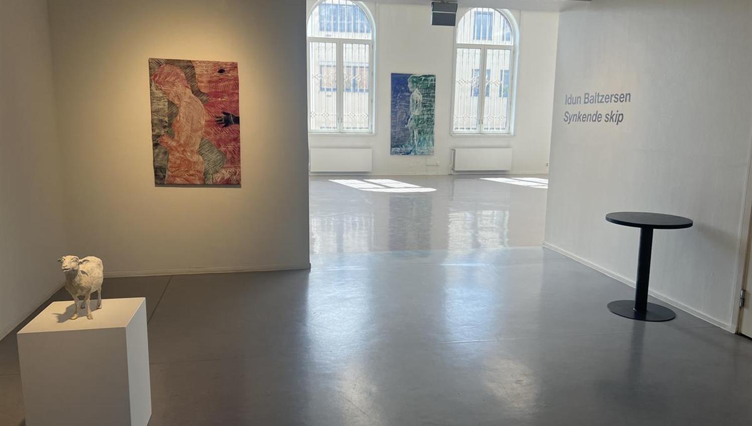 Modern exhibition space with artworks on the walls.