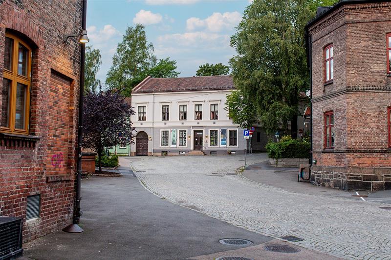 Exterior view of the Workers Museum in a quiet cobbled street surrounded by historic brick buildings and trees.
