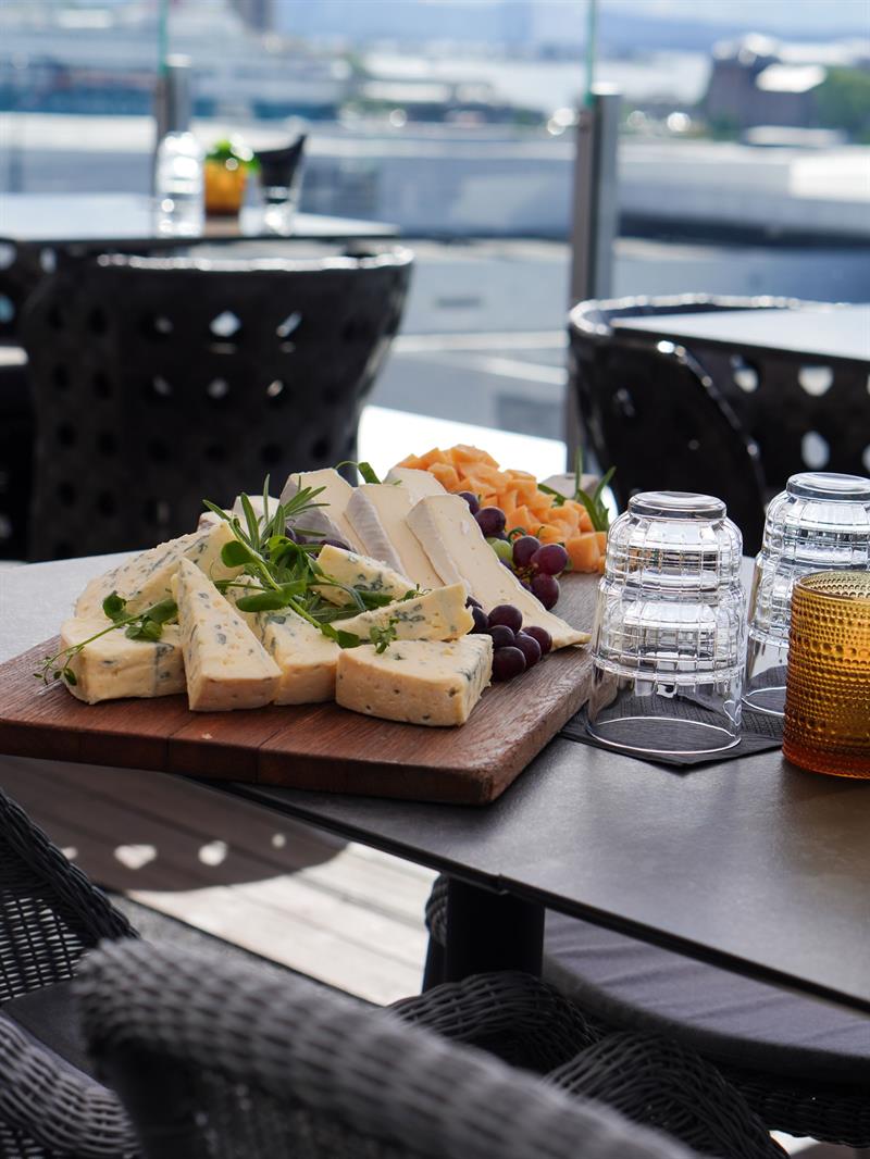 Cheese platter and light bites served on a rooftop terrace overlooking the city.