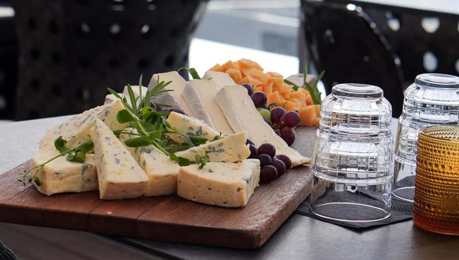 Cheese platter and light bites served on a rooftop terrace overlooking the city.