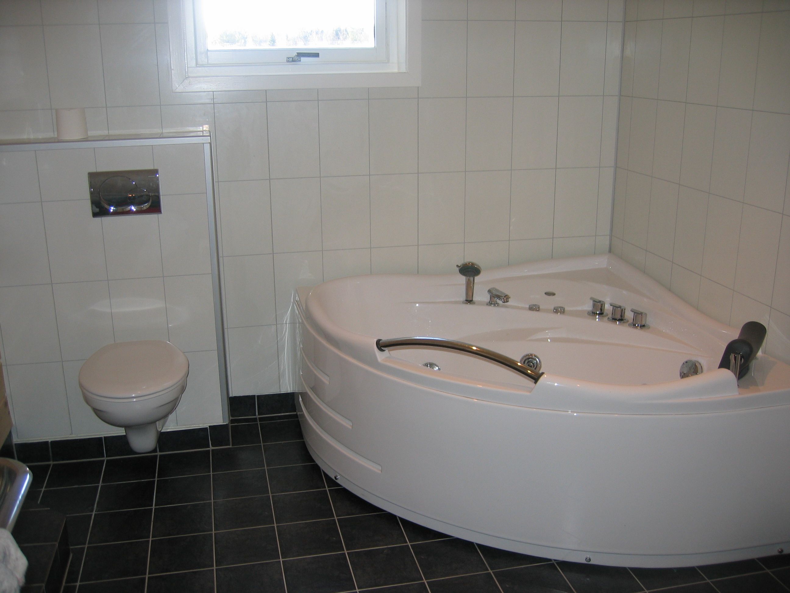 Bright and modern bathroom with a spacious corner bathtub.