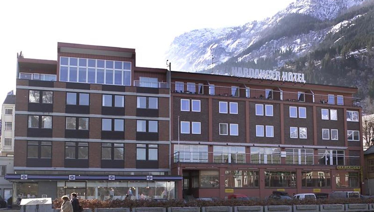 Hardanger Hotel in winter with snow-covered mountains in the background.