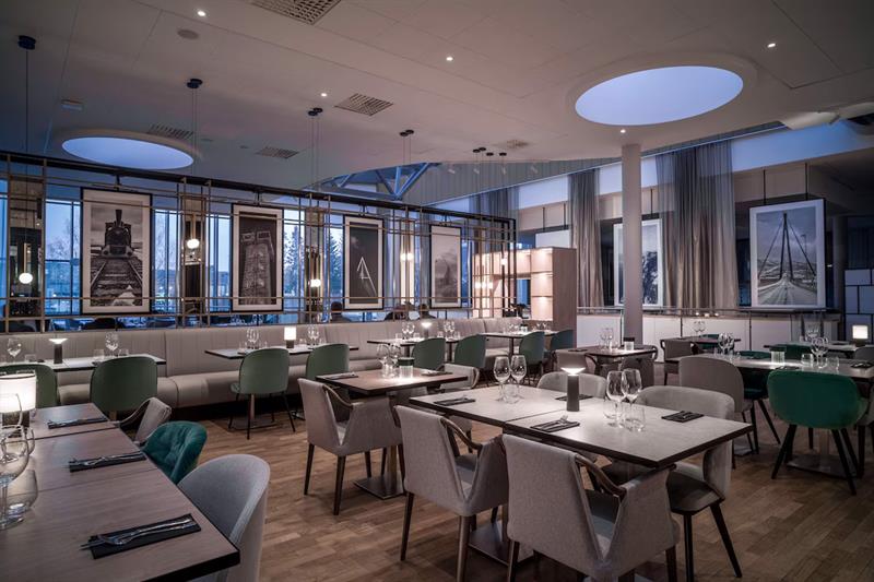 Restaurant interior with various dining tables set for dining, chairs and seating section