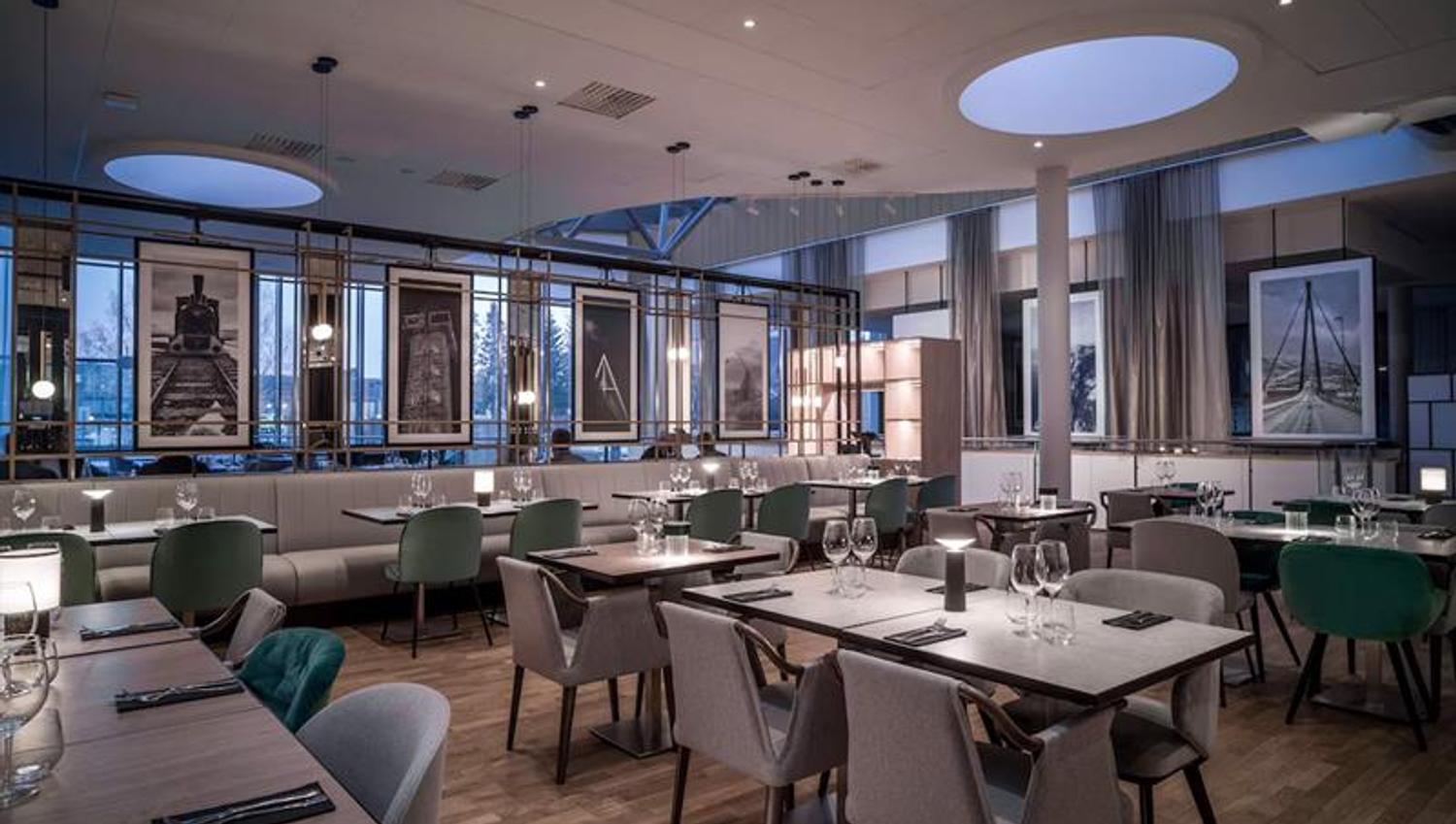 Restaurant interior with various dining tables set for dining, chairs and seating section
