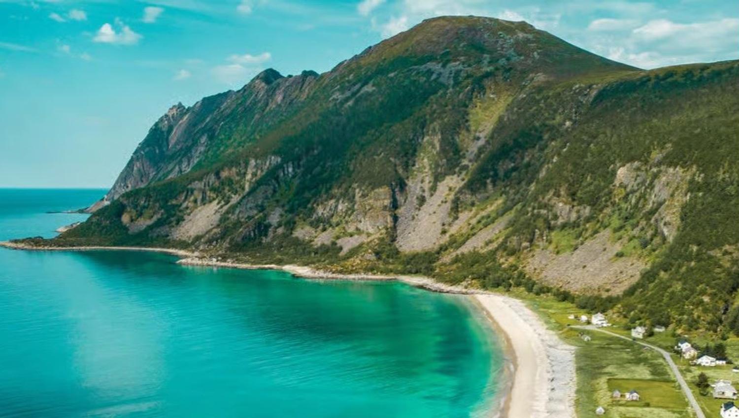 Blå fjord med fjell på ene siden