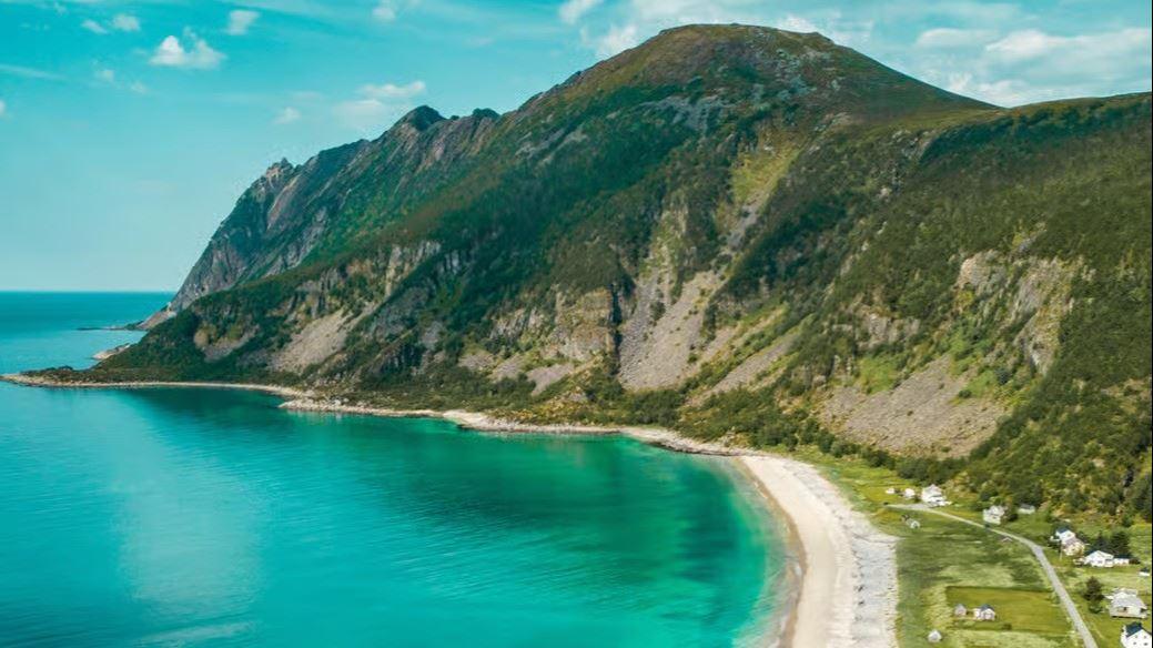 Blå fjord med fjell på ene siden