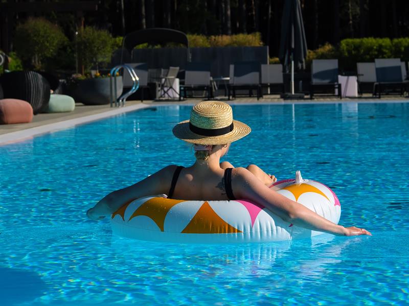 Outdoor pool The Well - lady with hat on a inflated madrass