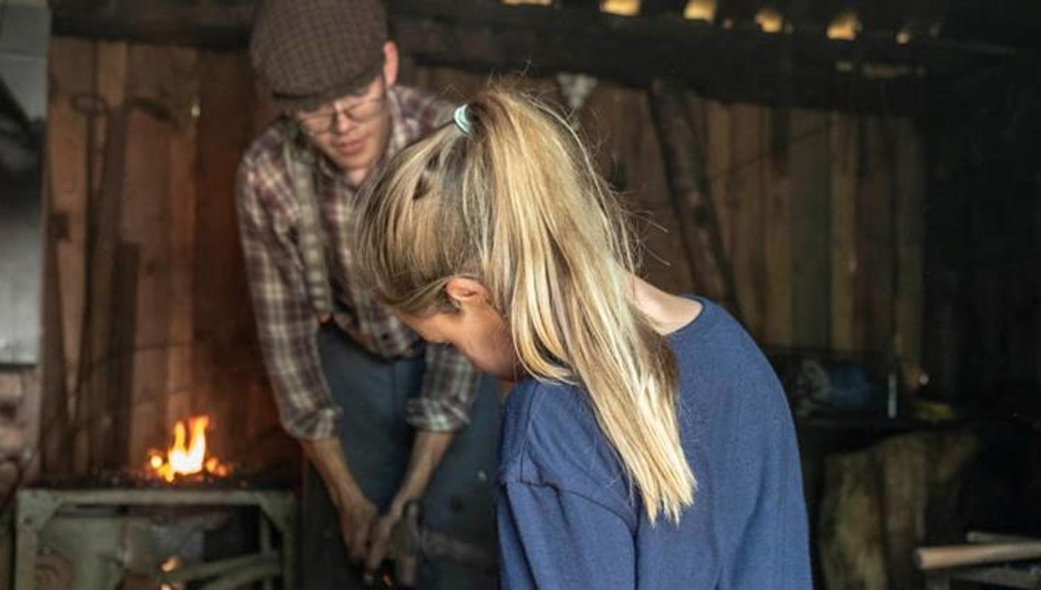 Man showing smithing to woman