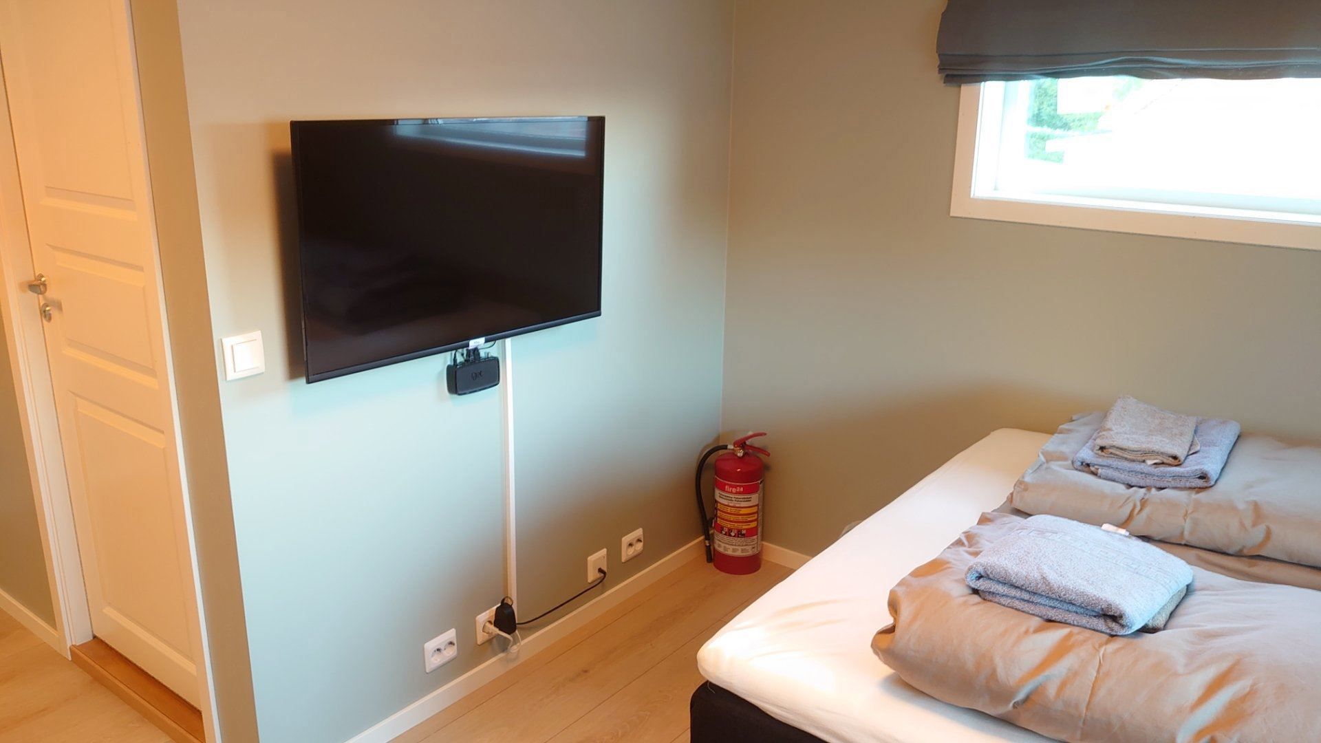 TV on a wall in a bedroom