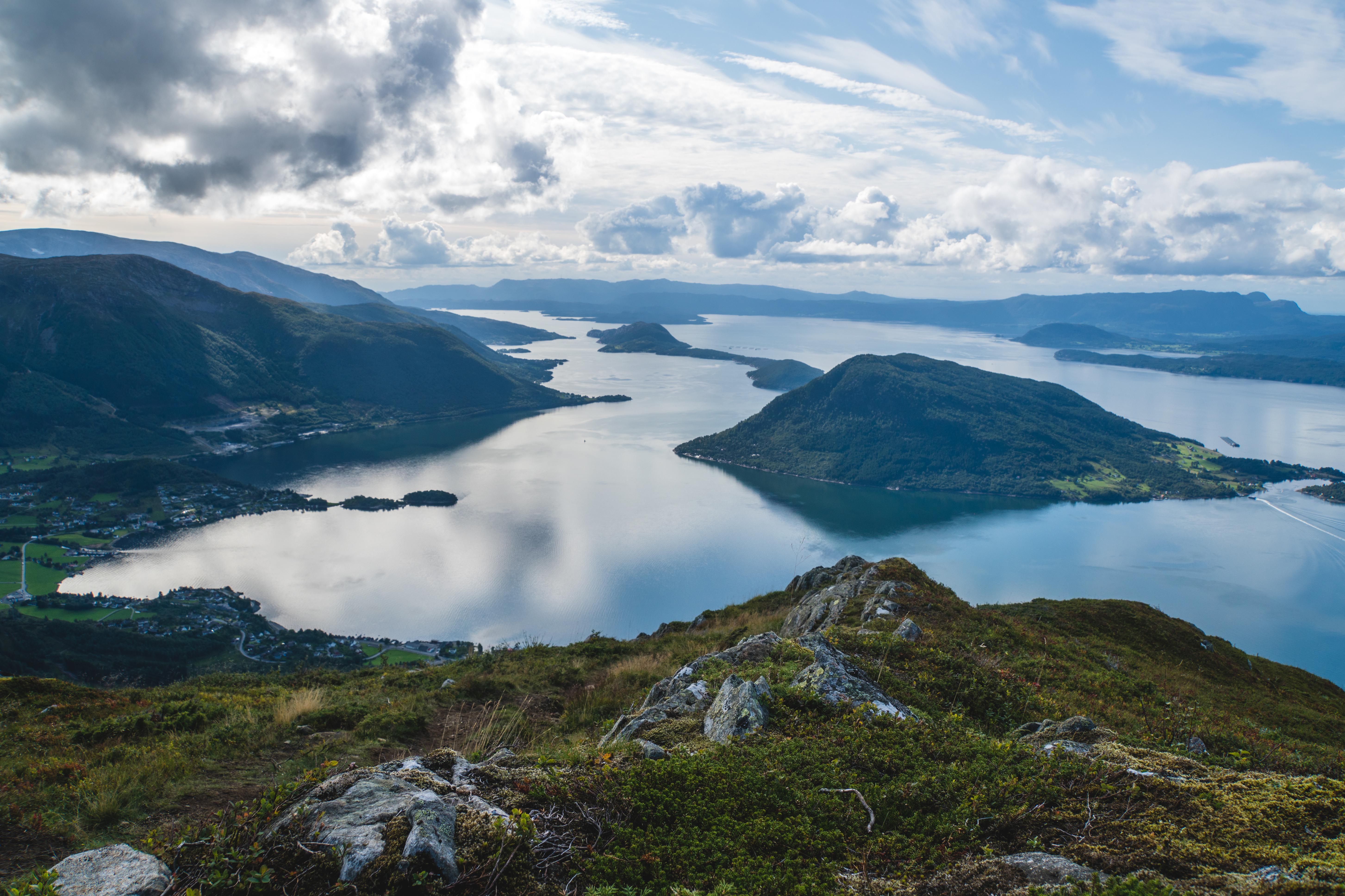 Storslått utsikt frå Malmangernuten over Hardangerfjorden med fjell, øyar og dramatisk skyspel.