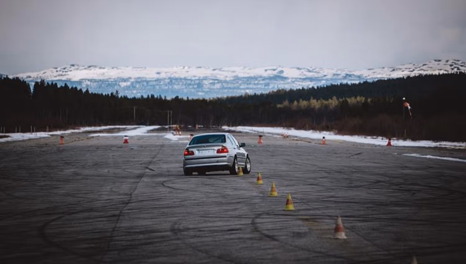 A car during the race and mountains on the background.