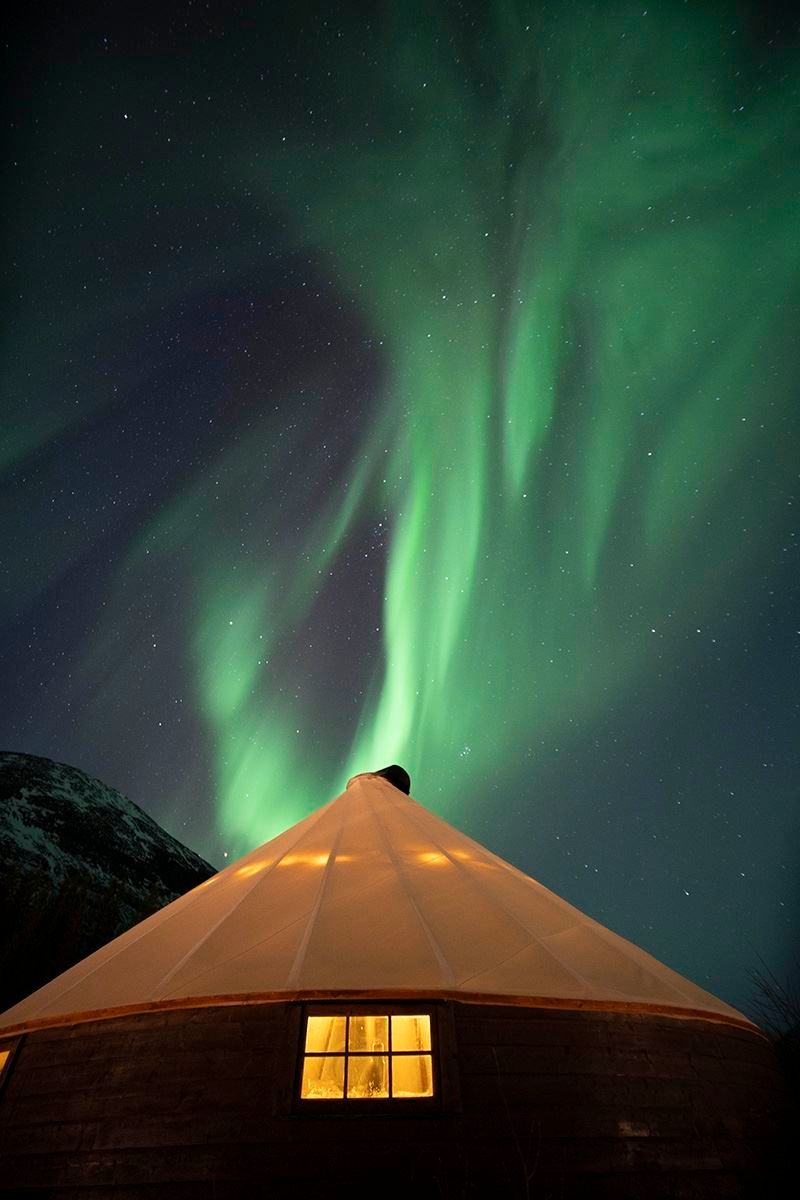 The Northern Lights show themselves above a lavvo