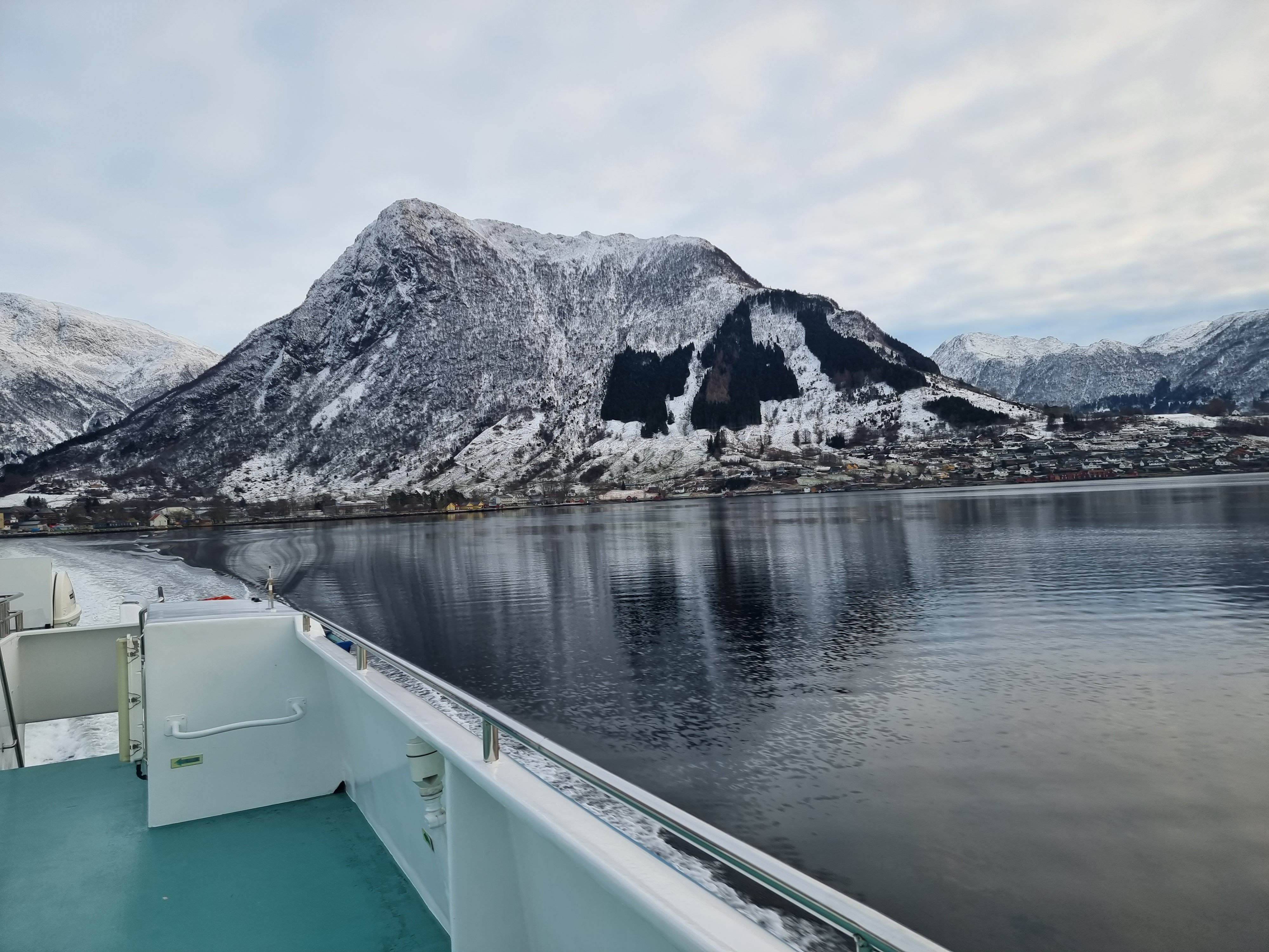 Hardangerfjordekspressen in a winter landscape with beautiful mountains as a backdrop.