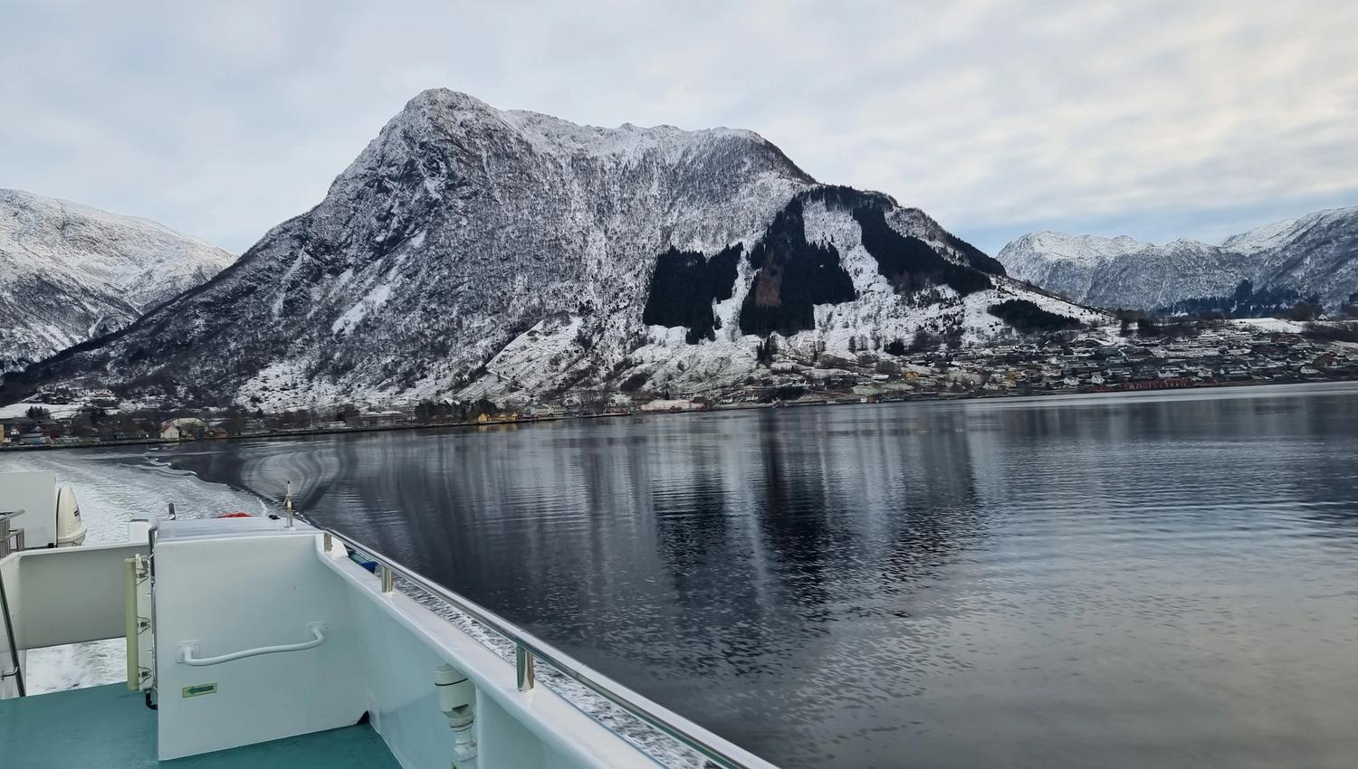 Hardangerfjordekspressen in a winter landscape with beautiful mountains as a backdrop.