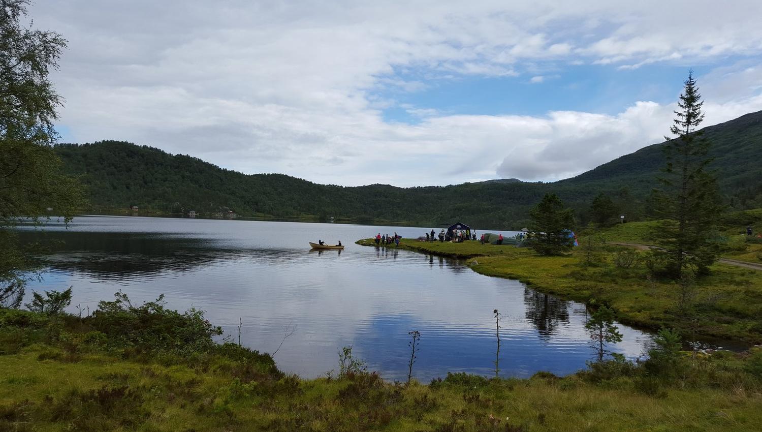 Peaceful day by the lake with boats and tents at Folgefonn Cabins and Farm Camping in Hardanger.