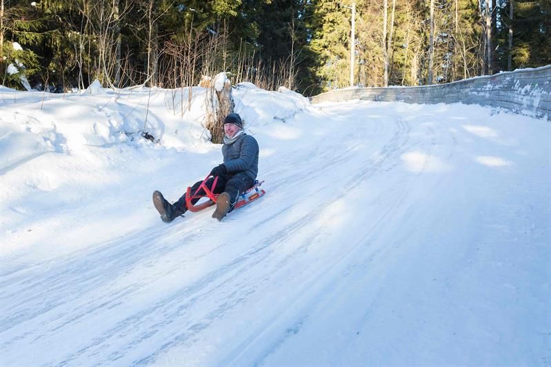 A person sledding down a snow-covered hill.