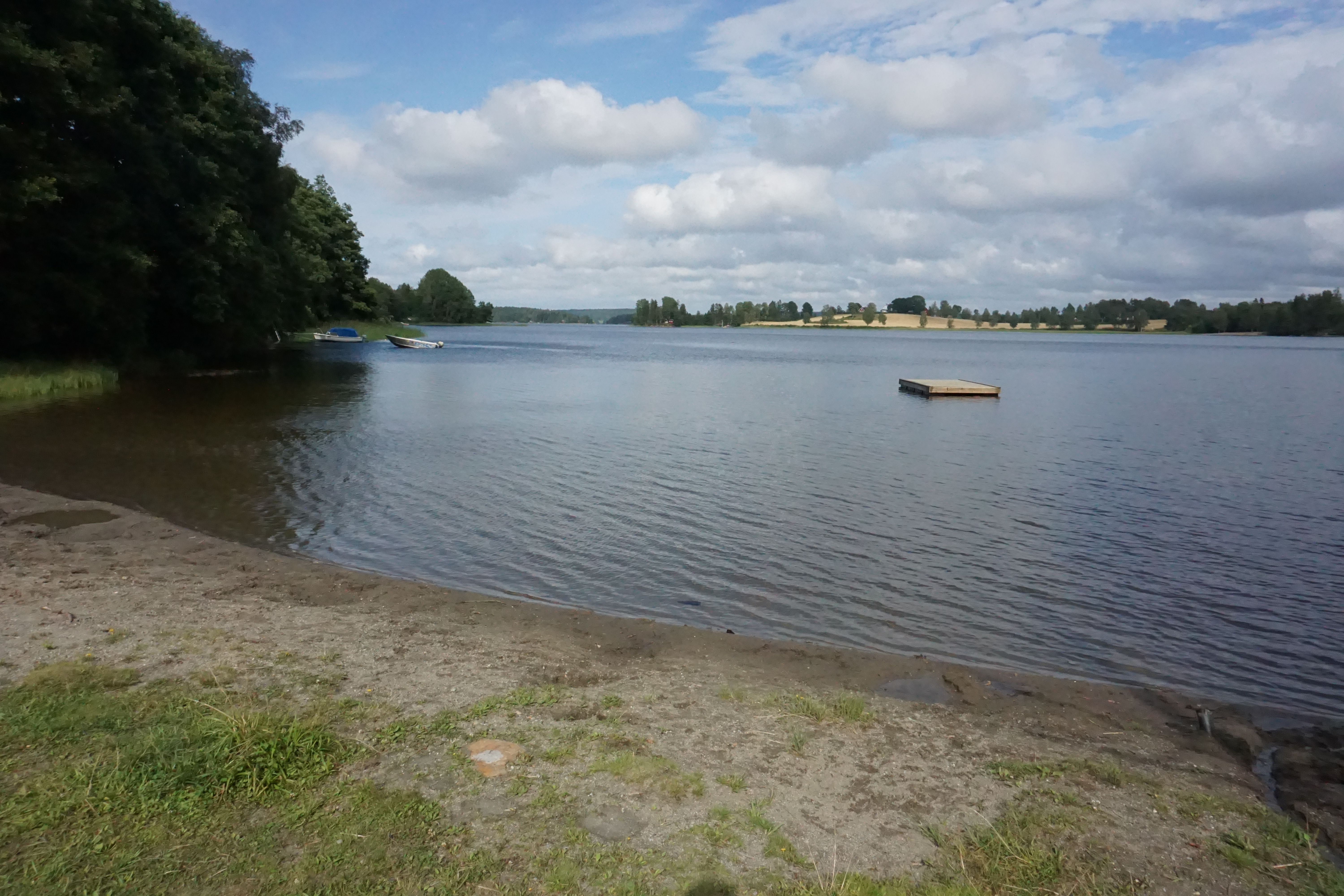 Strand med badebrygge i vannet
