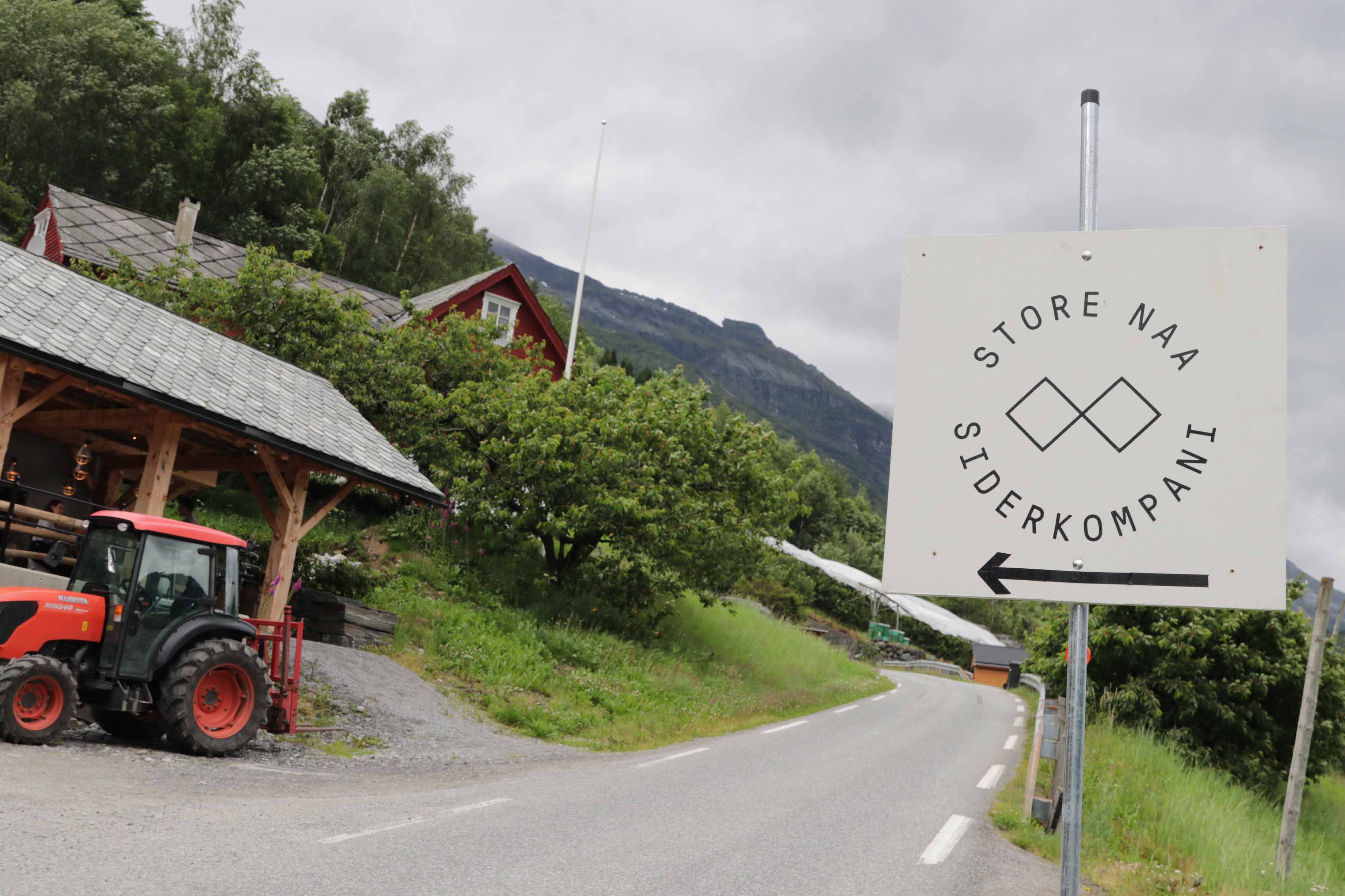 Signpost directing to Store Naa Cider Company by a country road in Hardanger.