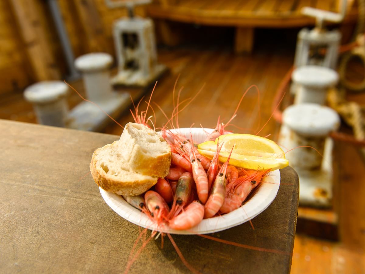 Shrimp in a bowl with bread and a slice of lemon