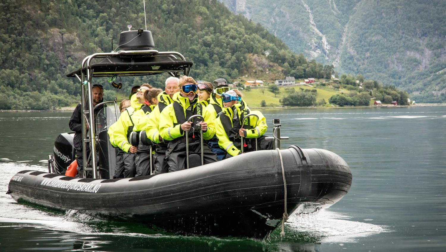 A rib boat filled with passengers, seen from the front.