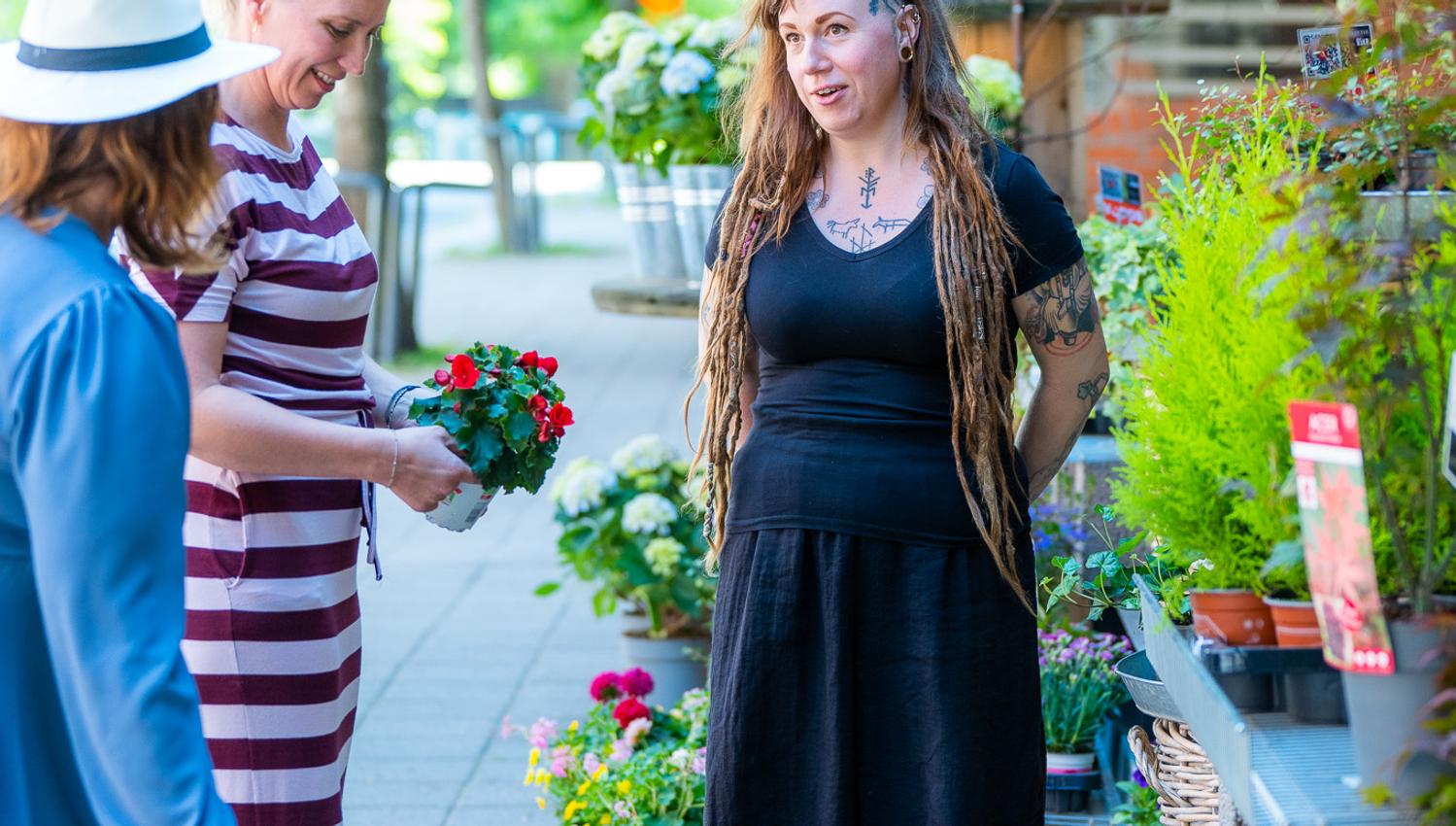 Shop employee in conversation with customers about which plants and what kind of care