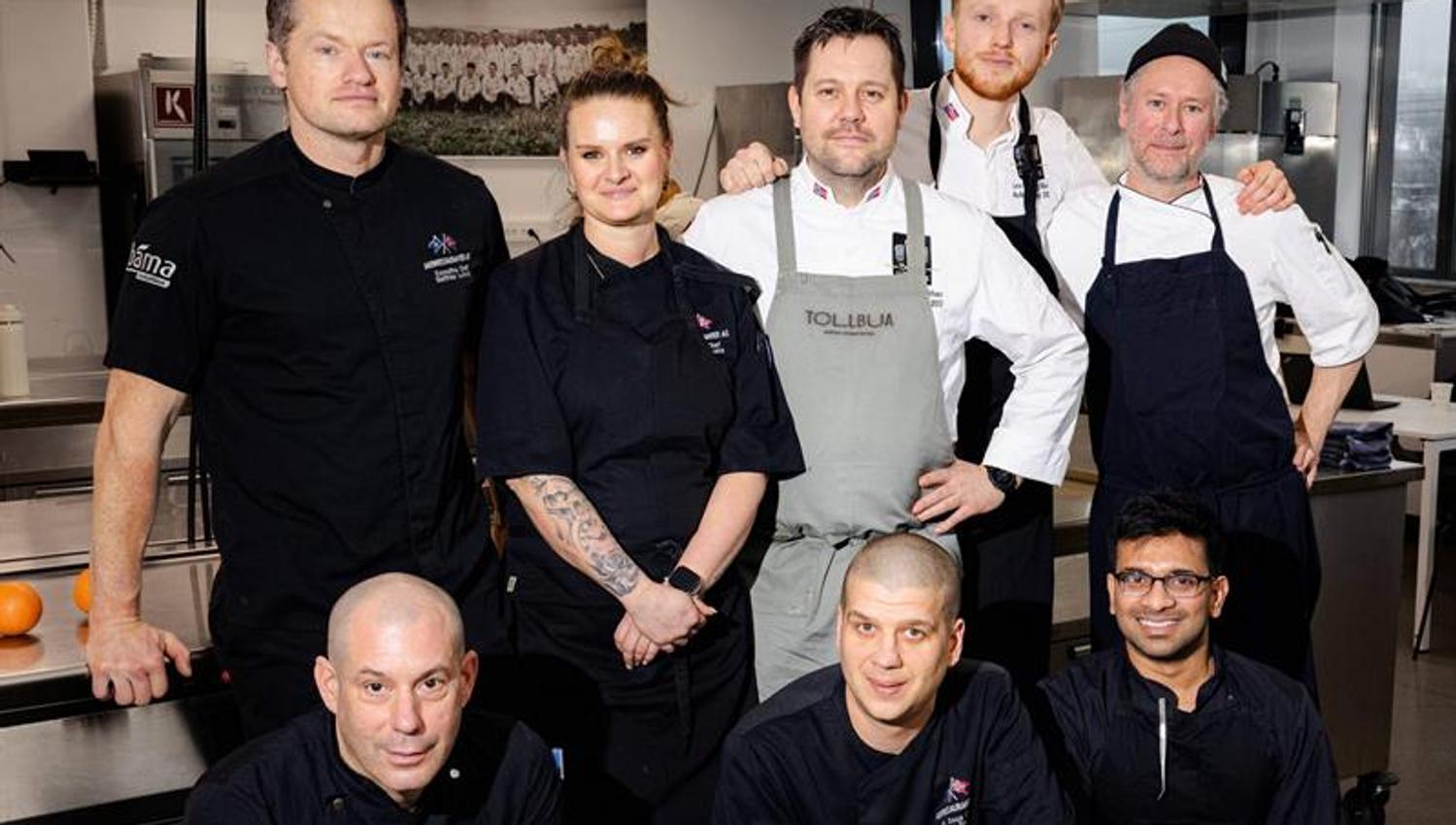 Chefs posing in a kitchen.