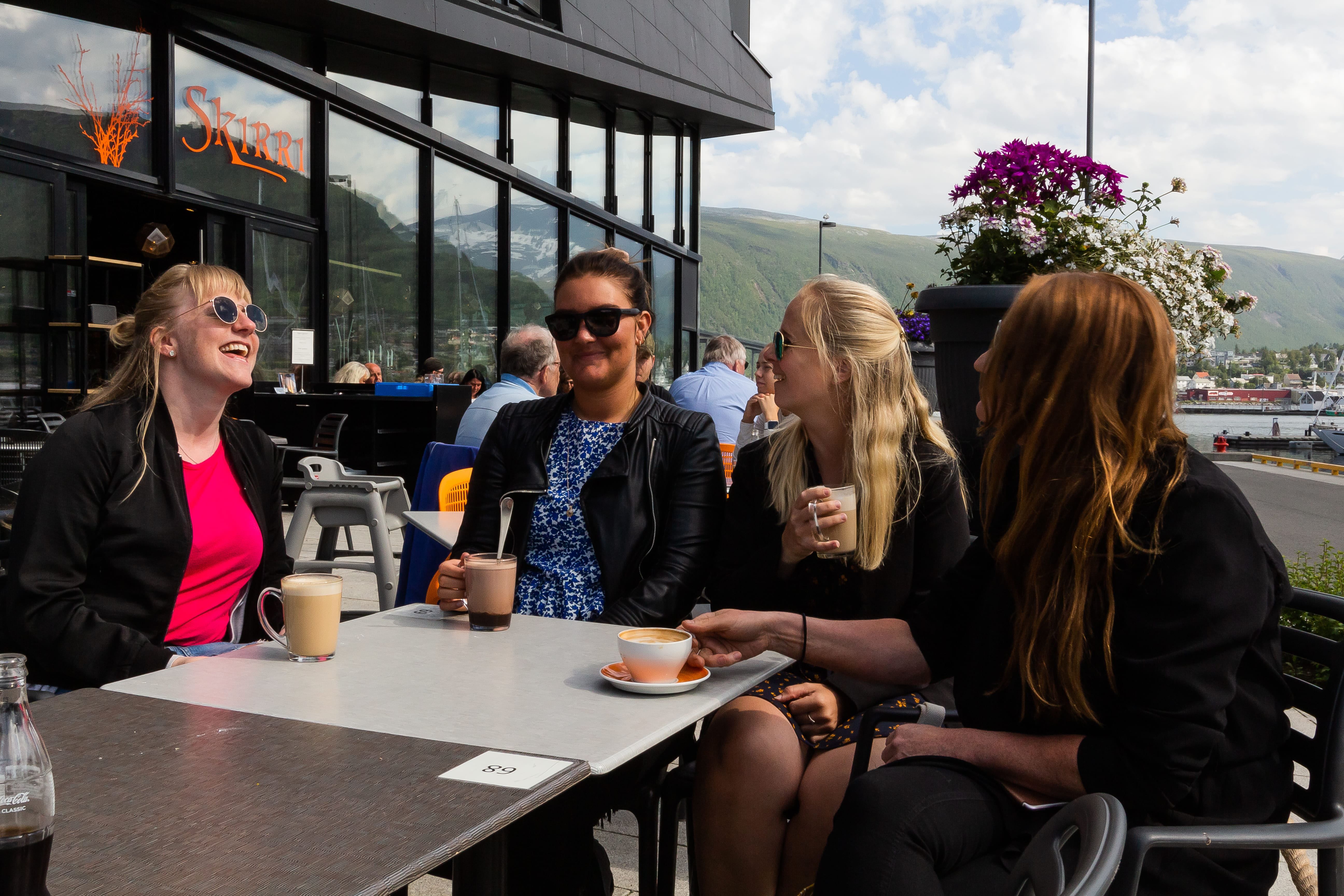 Friends enjoying coffee outside of a cafe
