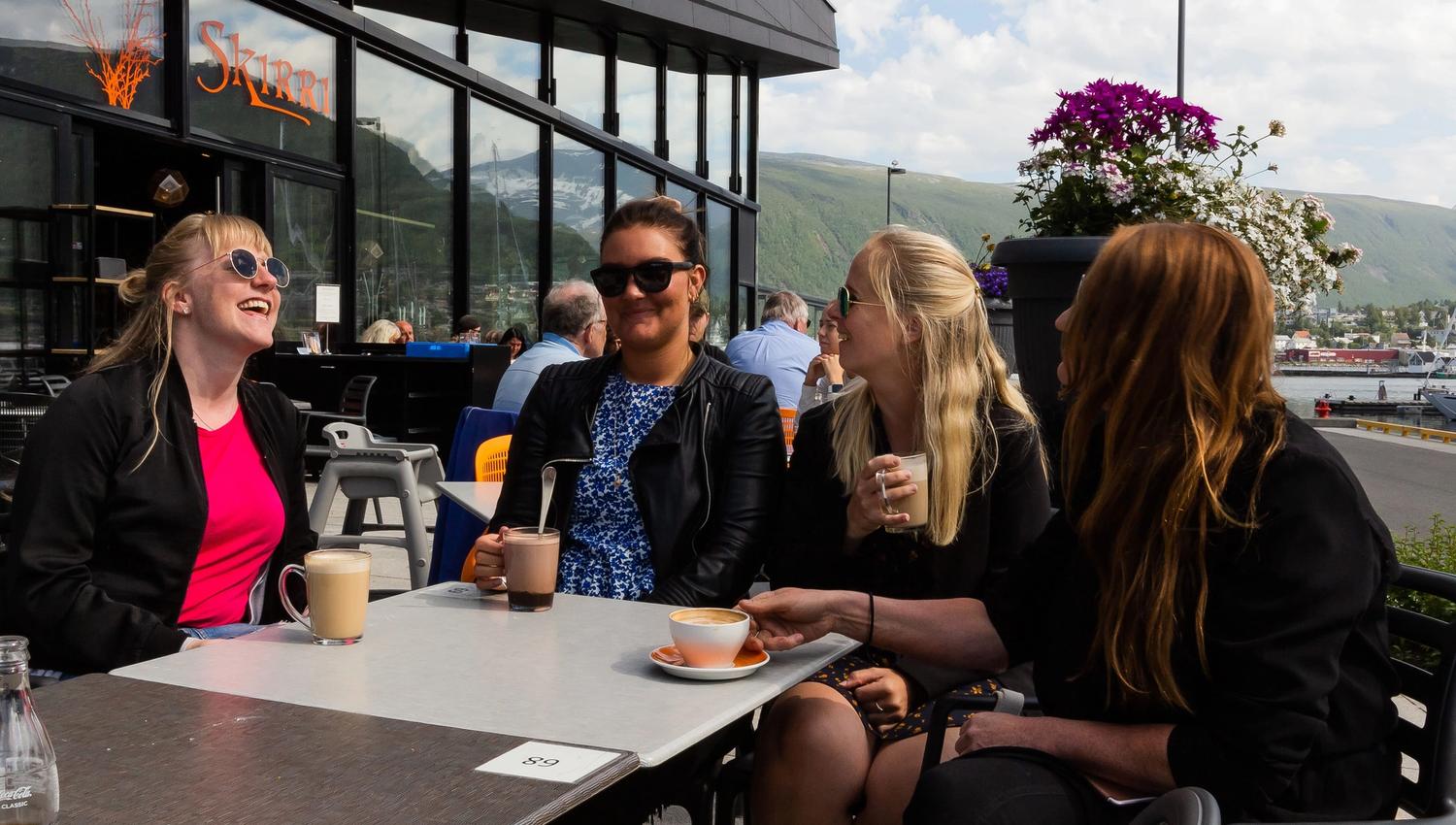 Friends enjoying coffee outside of a cafe