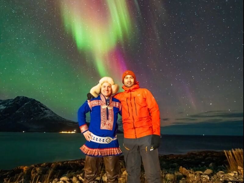 Tour leader and guest pose in front of the Aurora