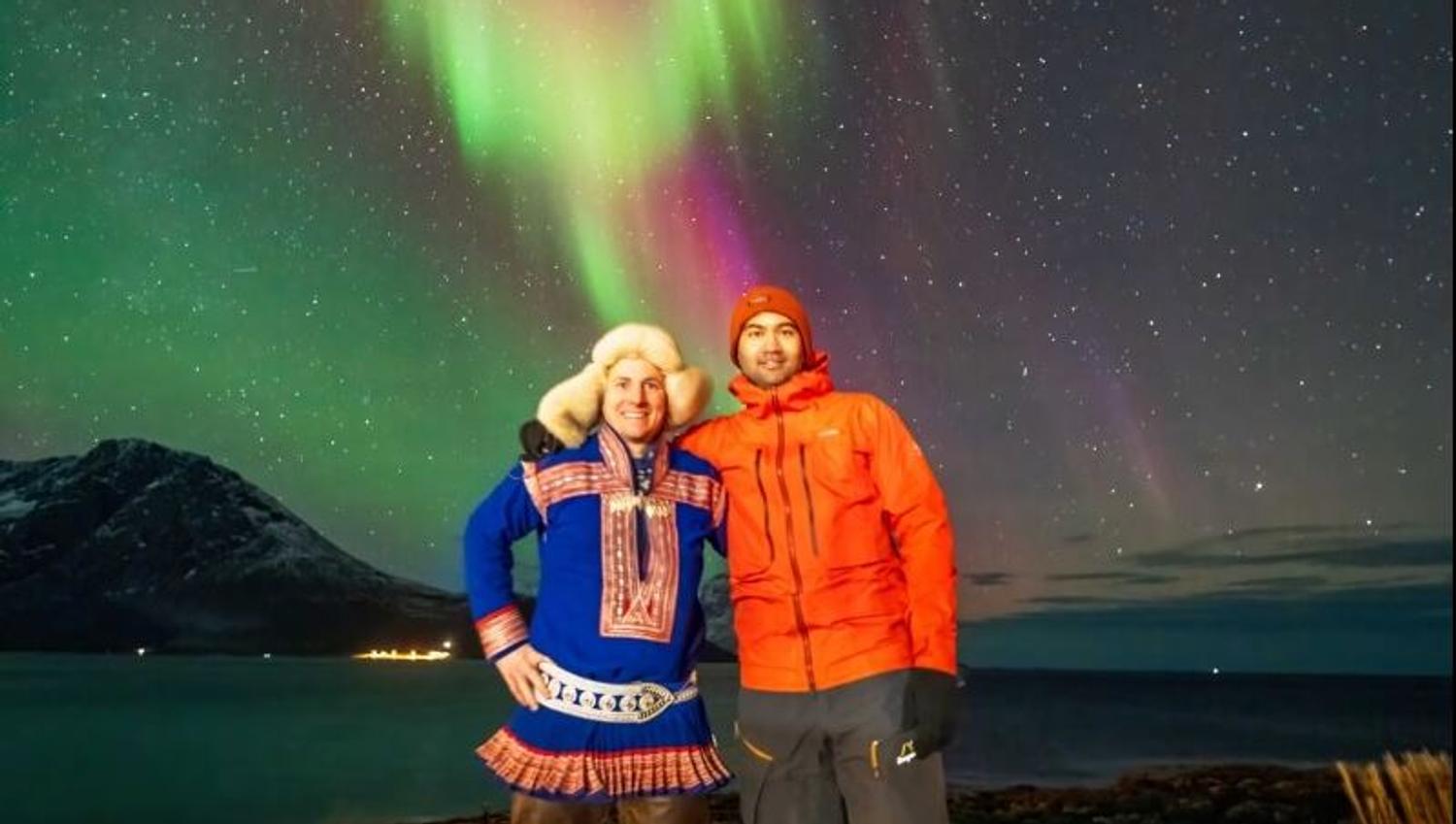 Tour leader and guest pose in front of the Aurora
