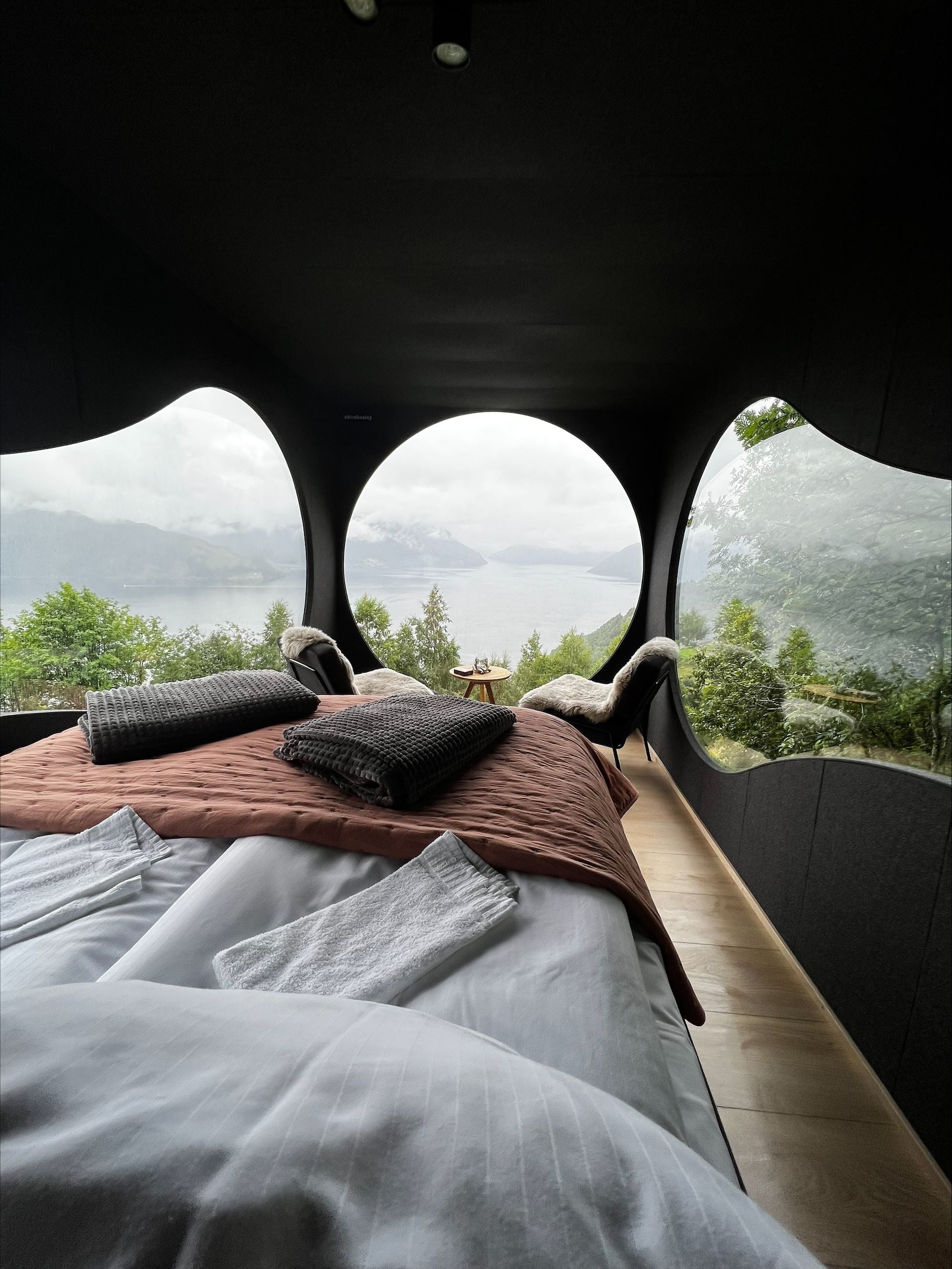 Stunning panoramic view from the Birdbox cabin at Skaara Living on Lotsberg in Nordfjord, surrounded by mountains and fjord landscape.