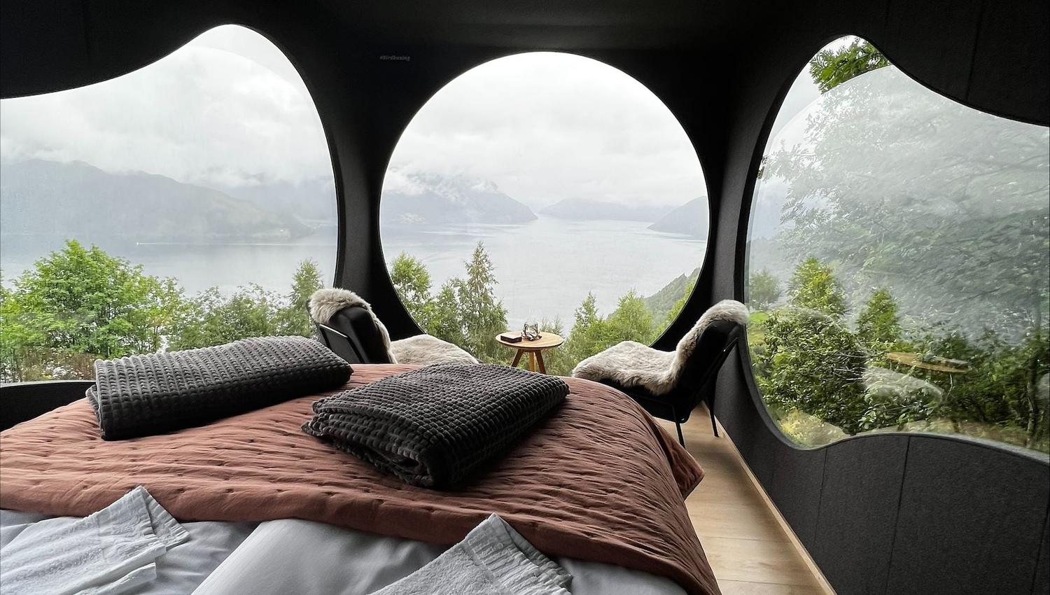 Stunning panoramic view from the Birdbox cabin at Skaara Living on Lotsberg in Nordfjord, surrounded by mountains and fjord landscape.