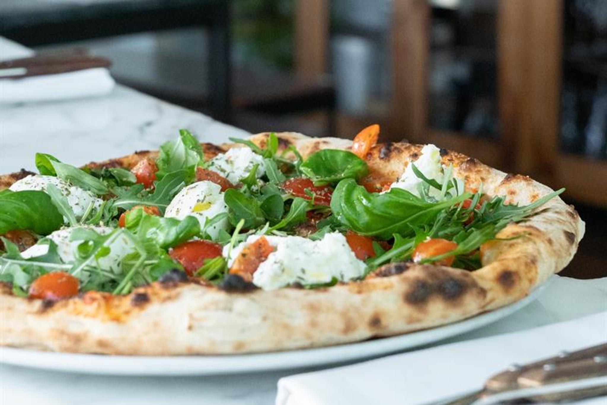 pizza med ruccola, basilikum, cherrytomater og mozzarella