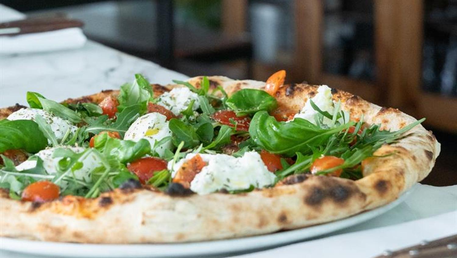 pizza med ruccola, basilikum, cherrytomater og mozzarella
