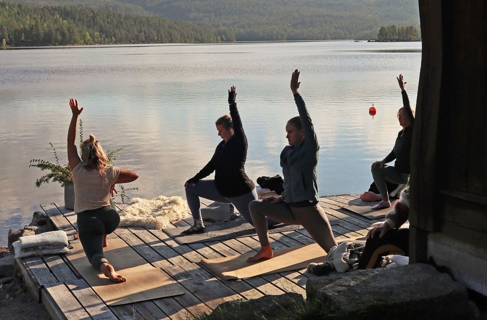 gruppe som har yoga ved vannet på Fiskebustøylen