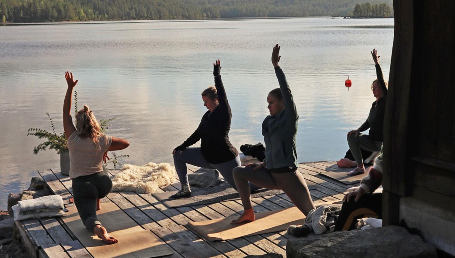 gruppe som har yoga ved vannet på Fiskebustøylen
