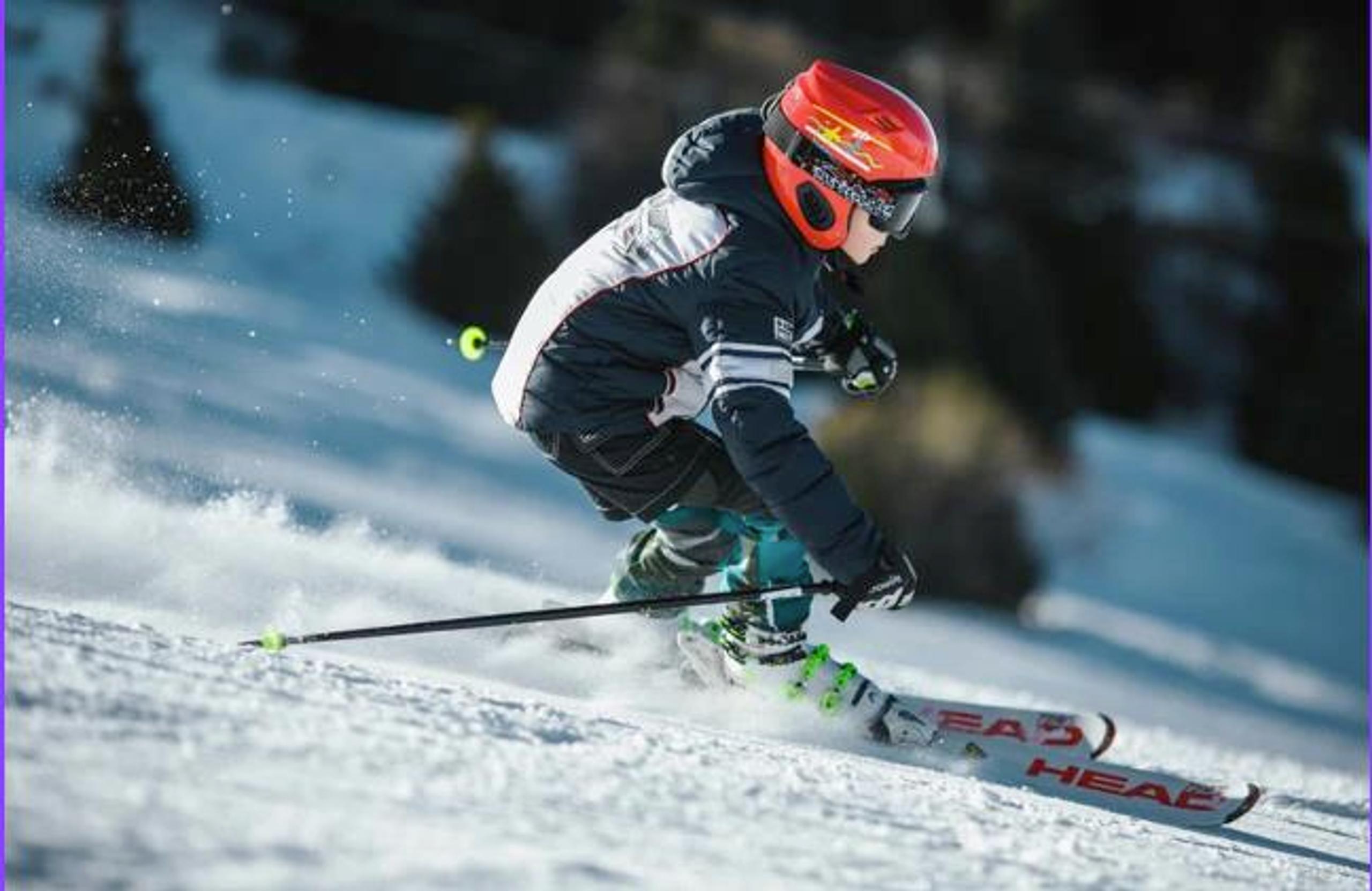Gutt med rød hjelm står slalom