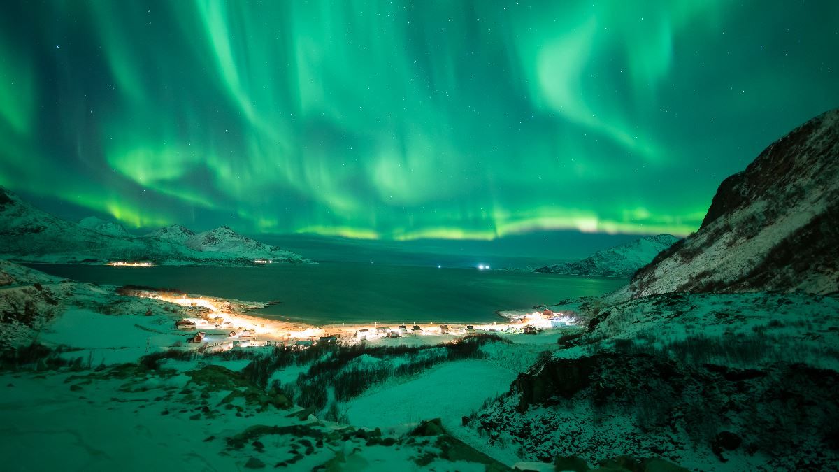 The Northern Lights illuminate the mountains and fjords during a guided Northern Lights tour from Tromsø in Northern Norway.