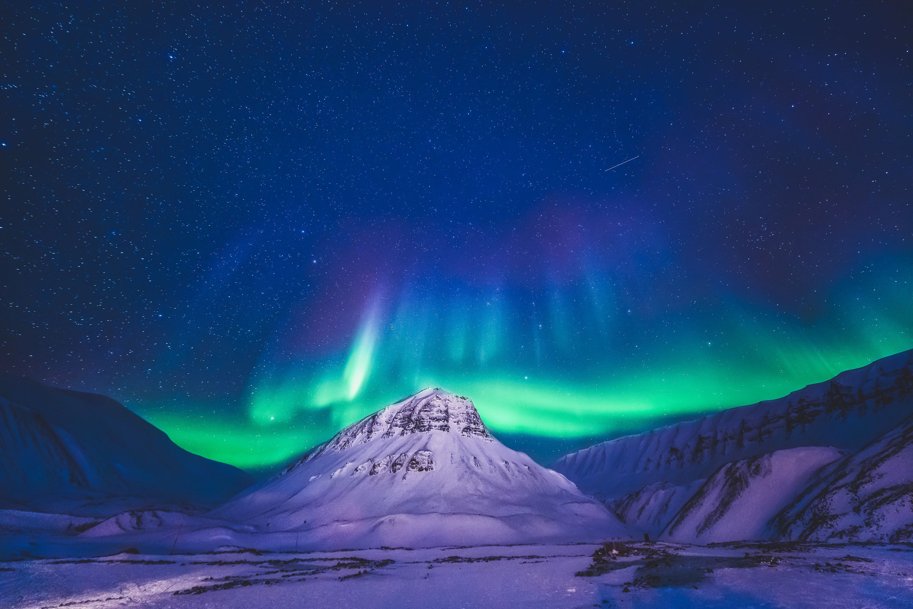 Nordlys danser over en fjelltopp