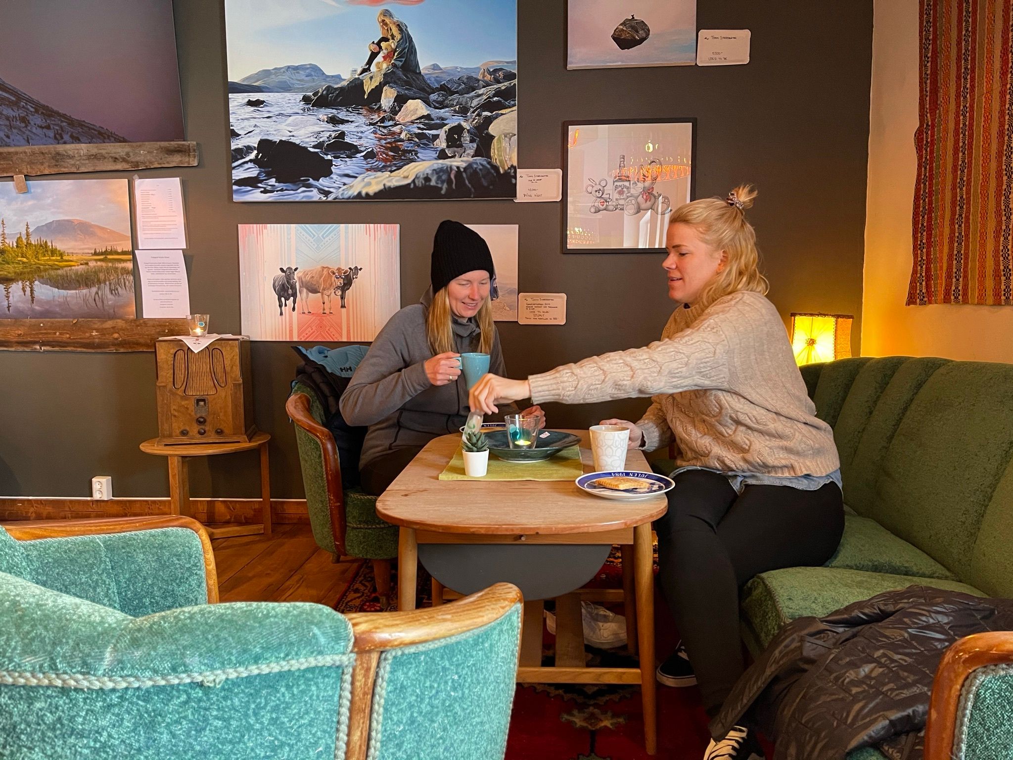 To damer som sitter ned og koser seg med kvikaku og kaffe